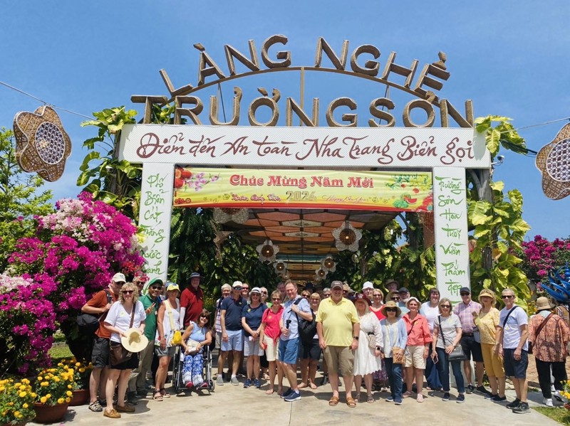 Turistas del Arcadia se toman fotos de recuerdo en la aldea de oficio tradicional de Truong Son, en Nha Trang. (Fotografía: baokhanhhoa.vn)