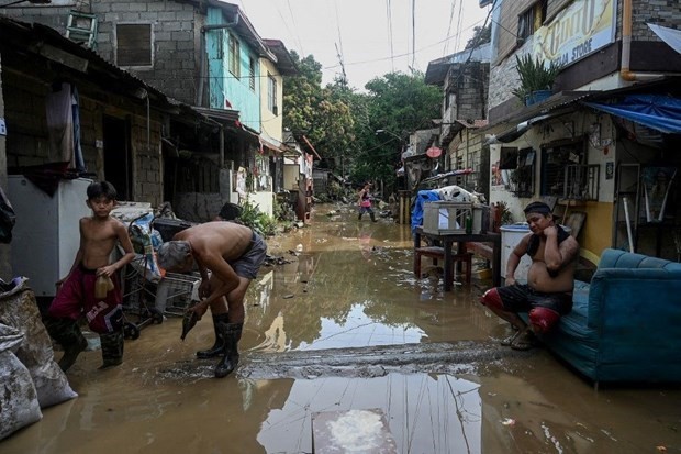 Los filipinos limpian sus casas inundadas después del súper tifón Noru, en septiembre de 2022. (Fotografía: philstar.com)
