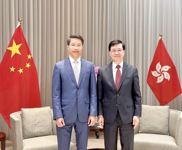 El cónsul general vietnamita, Pham Binh Dam (izquierda), y el jefe ejecutivo de la Región Administrativa Especial de Hong Kong, John Lee, en el encuentro. (Fotografía: VNA)