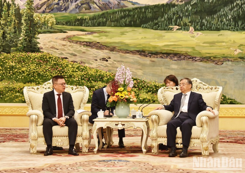 Reunión entre el presidente-editor de Nhan Dan, Le Quoc Minh (izquierda), y Li Shulei, miembro del Buró Político del Comité Central del PCCh y jefe de su Departamento de Publicidad. (Fotografía: Nhan Dan)