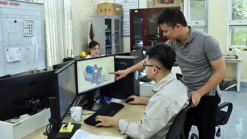 Ingenieros de la empresa Tomeco (del clúster industrial Ngoc Liep en Hanói) discuten el diseño de ventiladores industriales. (Fotografía: Nhan Dan)