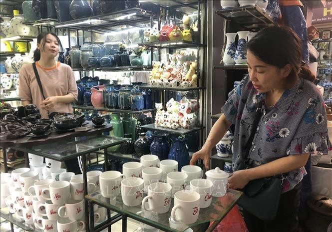 Clientes compran productos en el mercado de cerámica de Bat Trang, en Hanói. (Fotografía: VNA)