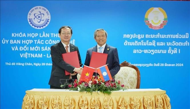 Los dos ministros intercambian documentos de la primera reunión del Comité de cooperación en Tecnología e Innovación Vietnam – Laos. (Fotografía: VNA)