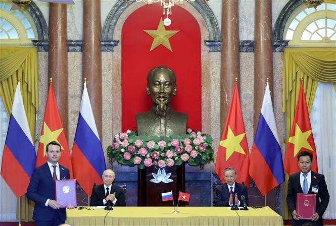 El presidente de Vietnam, To Lam (sentado a la derecha), y el presidente de Rusia, Vladimir Putin (sentado a la izquierda), presencian la entrega de documentos firmados entre los dos países. (Fotografía: VNA)