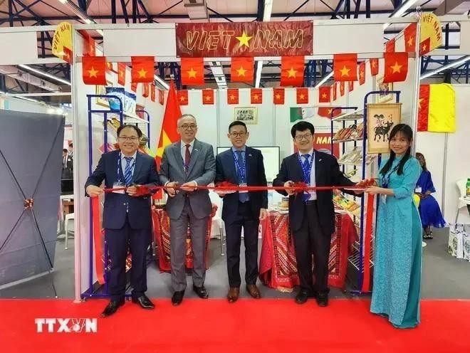 El embajador Tran Quoc Khanh (centro) y el consejero comercial Hoang Duc Nhuan (izquierda) cortan la cinta para inaugurar el pabellón de Vietnam en la feria. (Fotografía: VNA)