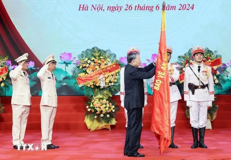 El presidente To Lam coloca la Orden de Mérito de Segunda Clase en la bandera tradicional del Departamento de Técnica Profesional del Ministerio de Seguridad Pública. (Fotografía: VNA)