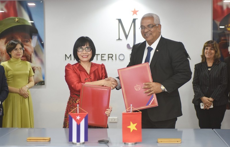 La viceministra de Justicia de Vietnam Dang Hoang Oanh y el ministro de Justicia de Cuba, Oscar Manuel Silvera Martínez, intercambian el memorando de entendimiento sobre cooperación entre la Academia Judicial del Ministerio de Justicia de Vietnam y la Escuela Ramal del Ministerio de Justicia de Cuba. (Fotografía: VNA)