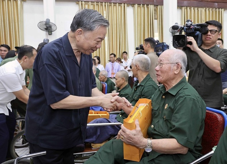 El presidente To Lam entrega regalos a los inválidos de guerra participantes en la reunión. (Fotografía: VNA)