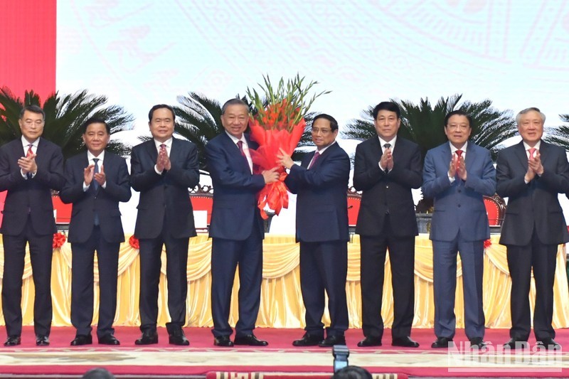 El miembro del Buró Político y primer ministro del Gobierno, Pham Minh Chinh, en nombre de los dirigentes del Partido y del Estado, entrega flores de felicitación al compañero To Lam por su elección como secretario general del PCV del XIII mandato. (Foto: Dang Khoa)