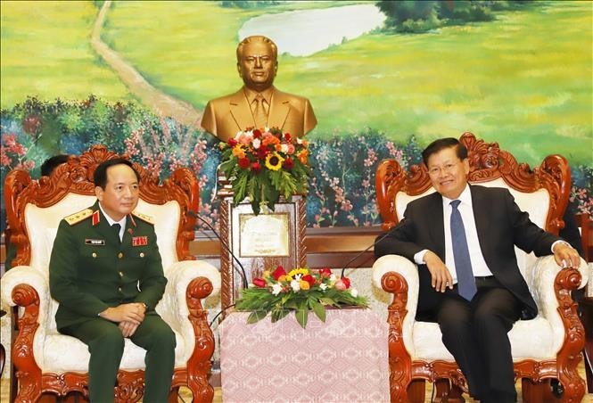 El coronel general Trinh Van Quyet, jefe de la Dirección General de Política del Ejército Popular de Vietnam (izquierda), y el secretario general del Partido Popular Revolucionario y presidente de Laos, Thongloun Sisoulith. (Fotografía: VNA)