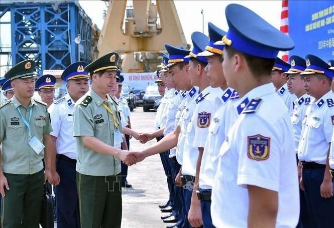 El general de división Liu Houjie (segundo desde la izquierda, primer plano), comisario político adjunto de la Guardia Costera de China, visita el barco 8004 del Escuadrón 11 del Mando de la Región 1 de la Guardia Costera de Vietnam. (Fotografía: VNA)