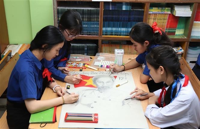 Alumnos de la escuela bilingüe laosiano-vietnamita de Nguyen Du pintan un cuadro del Tío Ho. (Fotografía: VNA)