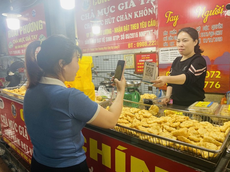 Una compradora realiza el pago sin efectivo en el mercado de Ha Long 2. (Fotografía: VNA)