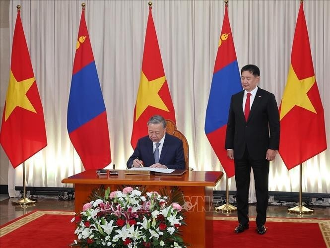 El secretario general del Partido Comunista y presidente de Vietnam, To Lam, firma el libro de invitados de honor. (Fotografía: VNA)