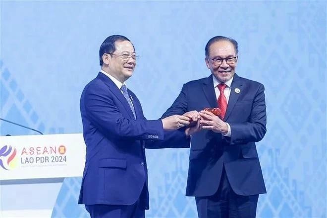 El primer ministro de Malasia, Anwar bin Ibrahim, recibe el mazo de la presidencia de la Asean de manos de su homólogo laosiano, Sonexay Siphandone. (Fotografía: VNA)