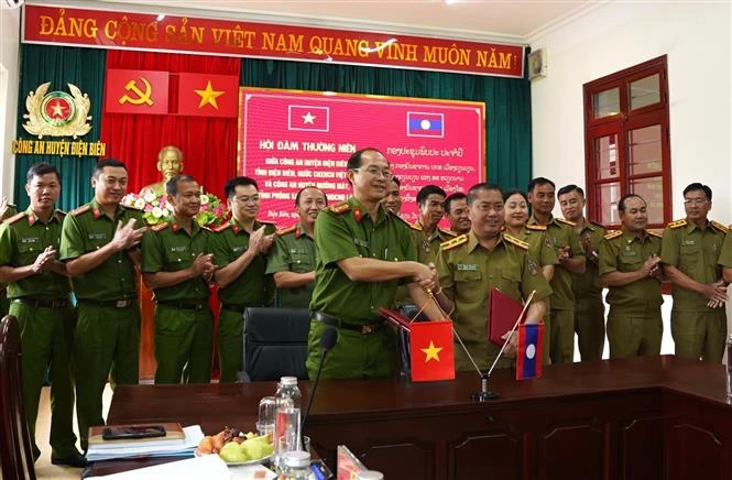 La policía de Dien Bien y el distrito limítrofe de Muang May firrman un acuerdo en el encuentro. (Fotografía: VNA)