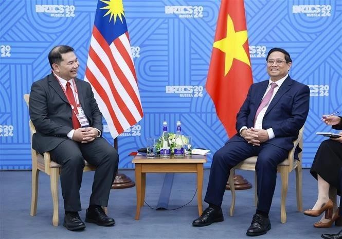 El primer ministro de Vietnam, Pham Minh Chinh, sostiene un encuentro con el ministro de Economía de Malasia, Rafizi Ramli. (Fotografía: VNA)