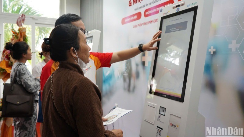 Se enseña a una paciente probar el sistema Quiosco de Salud inteligente en el Hospital de Da Nang. (Fotografía: Nhan Dan)