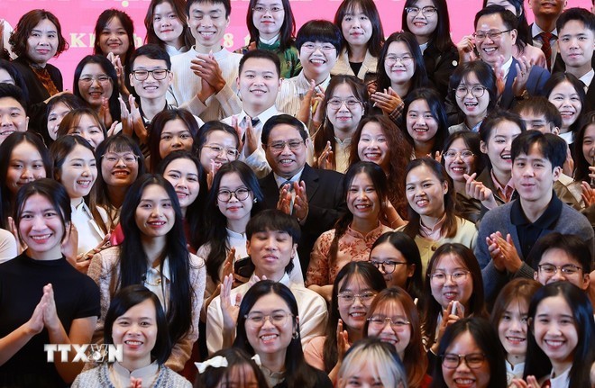 El primer ministro Pham Minh Chinh (centro) se reúne con estudiantes vietnamitas y representantes de la comunidad vietnamita en la ciudad de Chongqing. (Fotografía: VNA)