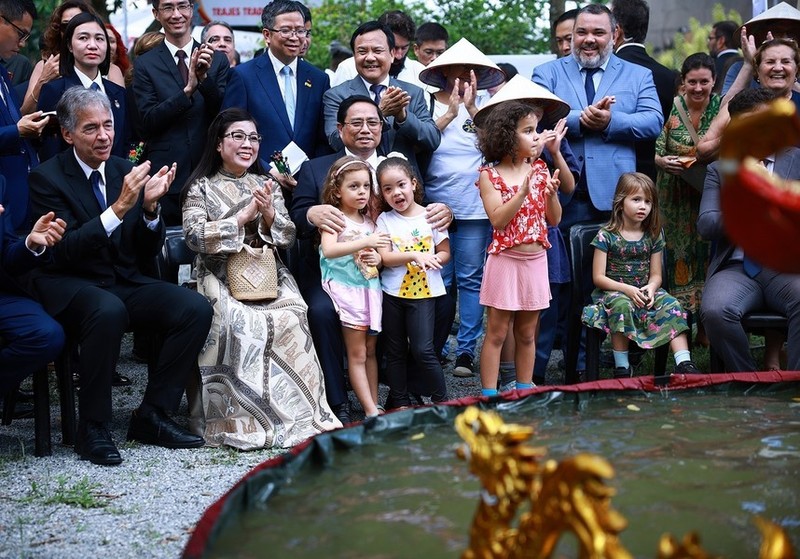 El primer ministro Pham Minh Chinh, su esposa y otros delegados disfrutan de un espectáculo de marionetas de agua en el evento. (Fotografía: VNA)