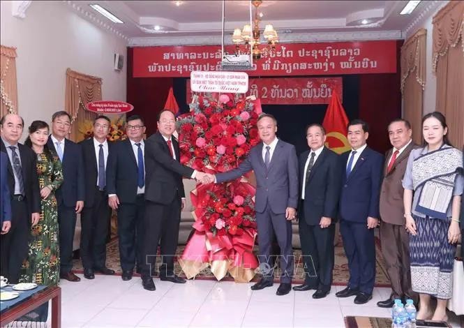 El subsecretario permanente del Comité del Partido en Ciudad Ho Chi Minh, Nguyen Ho Hai, (centro a la izquierda) entrega flores para felicitar al cónsul general adjunto de Laos, Amphay Souvannasen. (Fotografía: VNA)