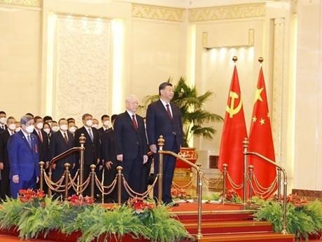 El secretario general del Partido Comunista de Vietnam, Nguyen Phu Trong, y el máximo dirigente partidista y presidente de China, Xi Jinping, escuchan los himnos nacionales de sus países. (Fotografía: VNA)