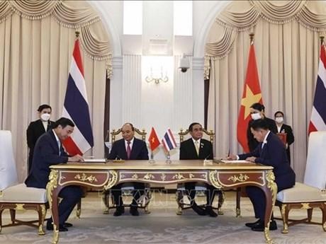 El presidente Nguyen Xuan Phuc (sentado, a la izquierda) y el primer ministro Prayut Chan-o-cha (sentado, a la derecha) son testigos de la firma del Memorando de Entendimiento sobre el establecimiento de una relación de ciudades hermanas entre la provincia de Khon Kaen de Tailandia y la ciudad Da Nang de Vietnam. (Fotografía: VNA)