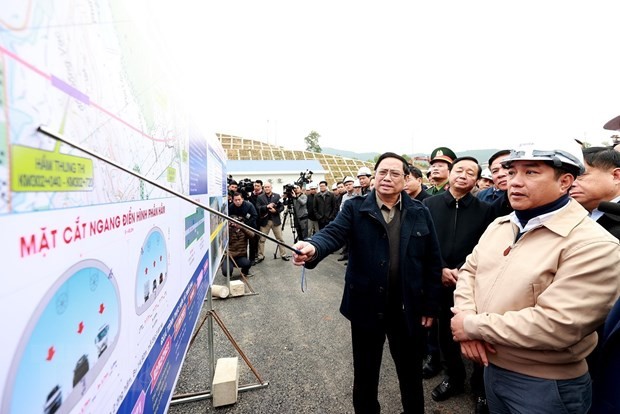 El primer ministro vietnamita, Pham Minh Chinh, y los gestores y obreros participantes en la construcción del ramo de la autopista Mai Son - la Ruta Nacional 45. (Fotografía: VNA)