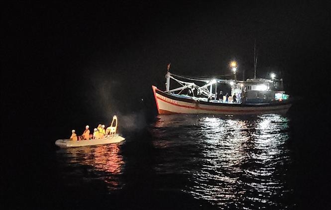 El bote salvavidas lleva al enfermo al barco SAR 412 para recibir tratamiento en Da Nang. (Fotografía: VNA)