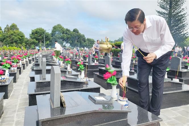 El miembro del Buró Político y jefe de la Comisión de Asuntos Internos del Comité Central del Partido Comunista de Vietnam, Phan Dinh Trac, coloca inciensos en las tumbas de mártires en el Cementerio. (Fotografía: VNA)