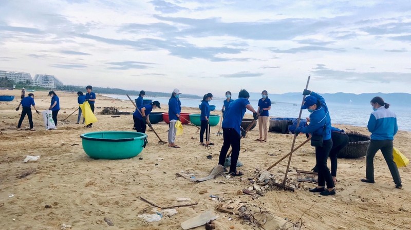 Jóvenes de la ciudad de Quy Nhon recogen basuras para limpiar la costa de la comuna de Nhon Ly. (Fotografía: VNA)