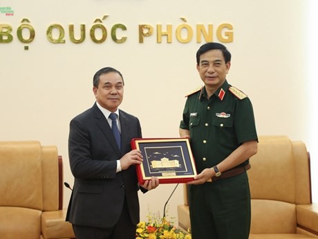 El ministro de Defensa, general Phan Van Giang (derecha), regala un obsequio al embajador de Laos en Vietnam, Sengphet Houngboungnuang. (Fotografía: qdnd.vn)