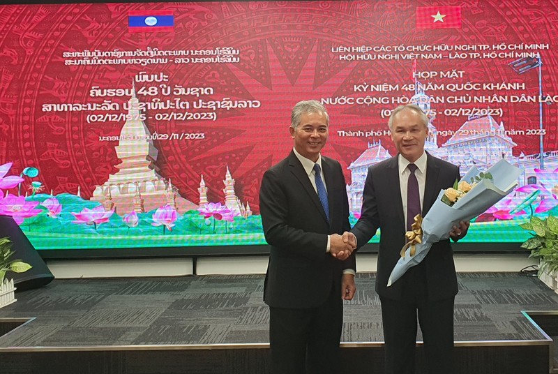 El presidente de la Asociación de Amistad Vietnam-Laos, Ngo Minh Chau, entrega flores para el cónsul laosiano en Ciudad Ho Chi Minh, Phonesy Bounmixay, con motivo del Día Nacional de Laos.