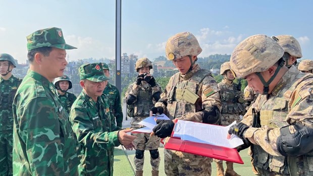 Los comandantes de patrulla de los guardias fronterizos de la provincia de Lao Cai y su homólogo chino de Mengzi firman un registro de patrulla bilateral en 2023. (Fotografía: bienphong.com.vn)