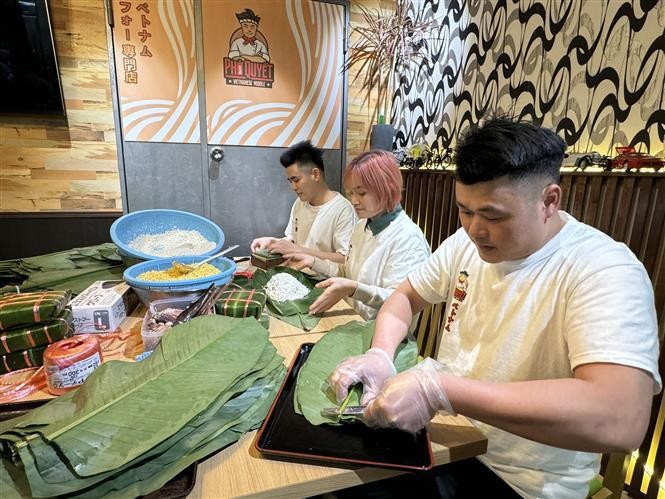 El dueño del restaurante Pho Quyet en Tokio, Dang Huy Quyet, y sus empleos preparan obsequios. (Fotografía: VNA)
