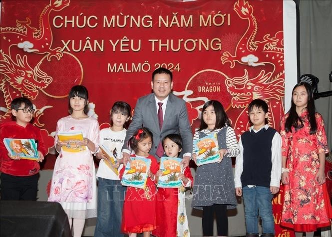 Entrega de libros en idioma vietnamita a niños coterráneos. (Fotografía: VNA)
