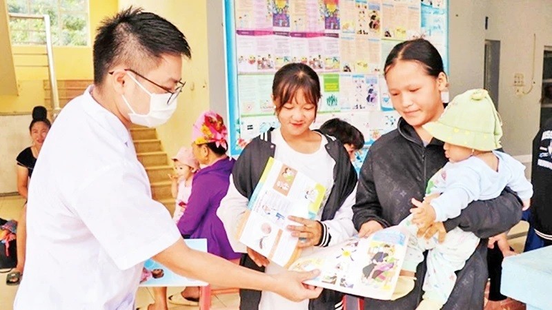 El personal médico de la comuna de Muong Cai, distrito de Song Ma, provincia de Son La, distribuye entre la población folletos propagandísticos sobre la planificación familiar. (Fotografía: Nhan Dan)
