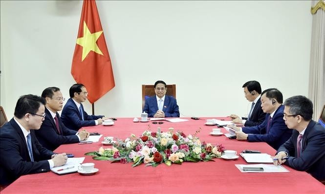 El primer ministro de Vietnam, Pham Minh Chinh, sostiene la llamada telefónica con su par singapurense, Lawrence Wong. (Fotografía: VNA)