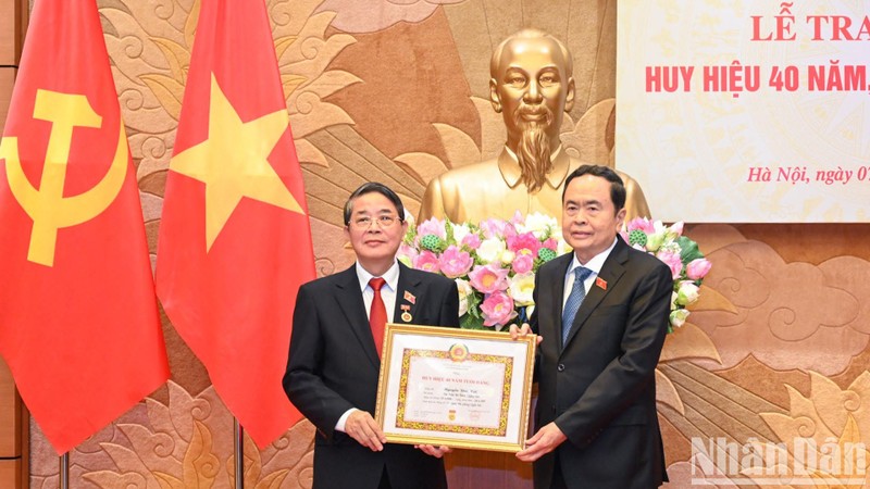 El presidente parlamentario Tran Thanh Man (derecha) entrega la insignia por 40 años de membresía del PCV a Nguyen Duc Hai, miembro del Comité Central del Partido y miembro del Comité de asuntos partidistas de la AN y vicepresidente del Parlamento. (Fotografía: Nhan Dan)