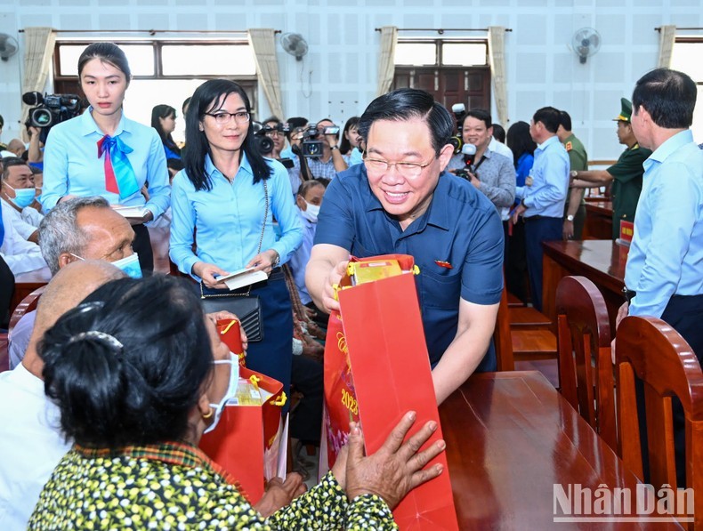 El presidente de la Asamblea Nacional, Vuong Dinh Hue, entrega regalos del Tet a los pobres.