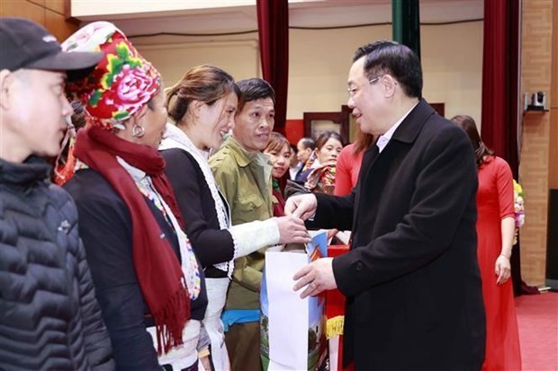El presidente de la Asamblea Nacional, Vuong Dinh Hue, entrega obsequios a los beneficiarios de la política social, los hogares pobres y los trabajadores y soldados desfavorecidos en el distrito de Bat Xat, en la provincia fronteriza norteña de Lao Cai. (Fotografía: VNA)