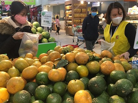 Pobladores compran productos expuestos en Big C Thang Long (Fotografía: VNA)