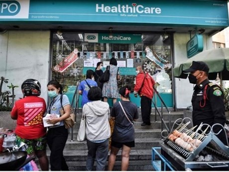 La gente hace cola para comprar pruebas subvencionadas de antígeno rápido (ATK) del Covid-19 en una farmacia de la Organización Farmacéutica del Gobierno en Bangkok en enero de 2022. (Foto: AFP/VNA)