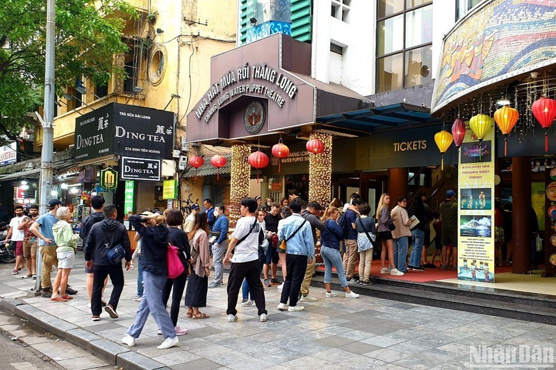Turistas hacen fila para comprar boletos a un espectáculo de marionetas de agua. (Foto: T. LINH)