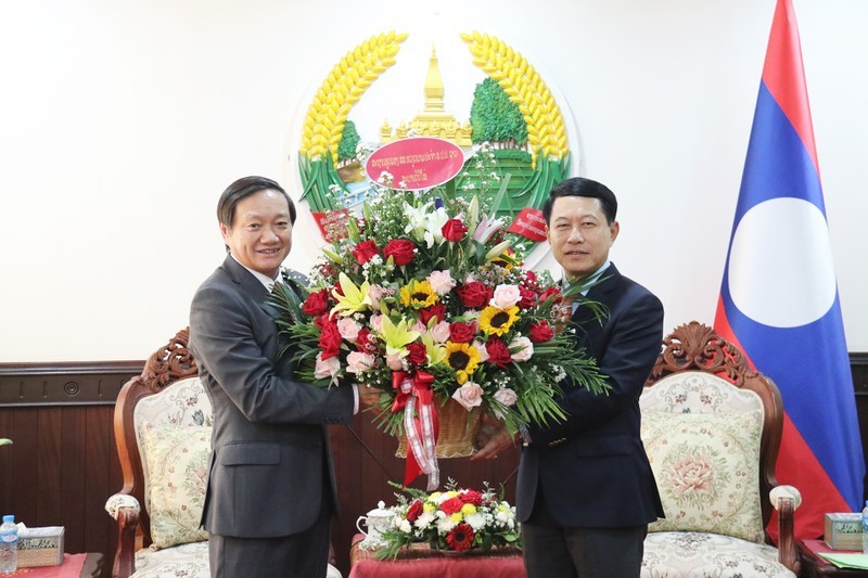 El embajador vietnamita en Laos, Nguyen Ba Hung, entrega flores de felicitación al viceprimer ministro y canciller laosiano, Saleumxay Kommasith. (Foto: Nhan Dan)