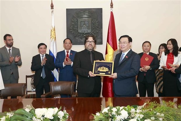 El presidente de la Asamblea Nacional, Vuong Dinh Hue, entrega un recuerdo al alcalde interino de la ciudad de Montevideo, Mauricio Zunino. (Foto: VNA)