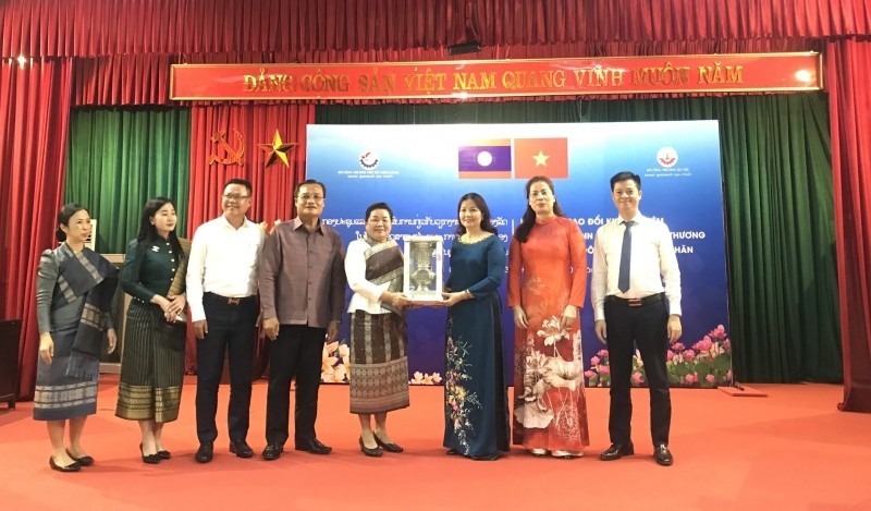 Representantes de los Servicios de Industria y Comercio de Hanói y Vientián entregan regalos de recuerdo.