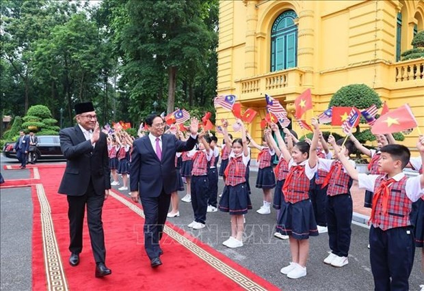 El primer ministro vietnamita, Pham Minh Chinh, y su homólogo malasio, Anwar Ibrahim, en la ceremonia de bienvenida (Foto: VNA)