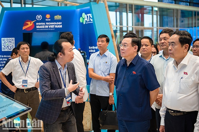 El presidente de la Asamblea Nacional, Vuong Dinh Hue, y los delegados visitan el stand de exhibición de productos en la Conferencia. (Foto: Nhan Dan)