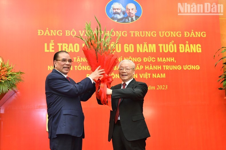 El secretario general del PCV, Nguyen Phu Trong, entrega flores de felicitaciones a Nong Duc Manh, exsecretario general del PCV. (Foto: Nhan Dan)